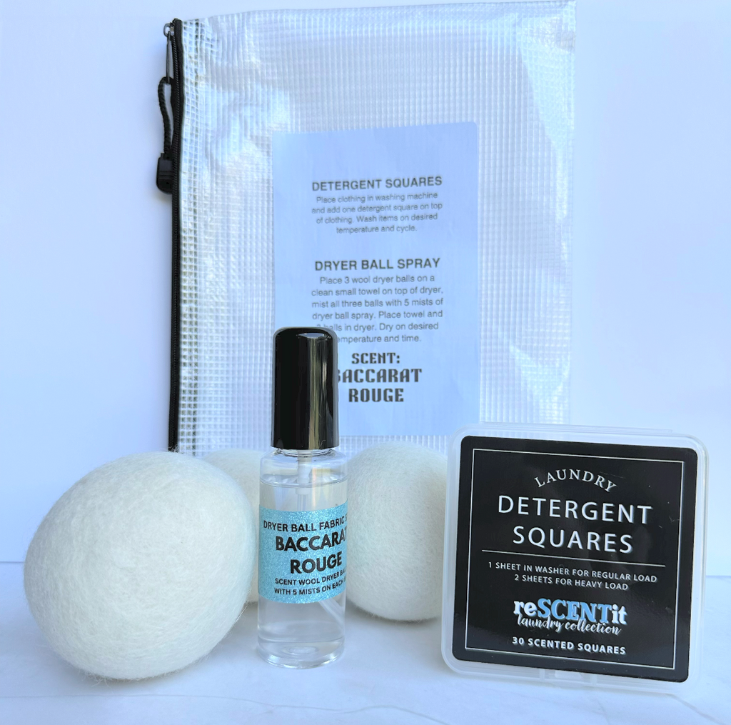 Laundry products including dryer balls, spray bottle, and detergent squares on a light blue background