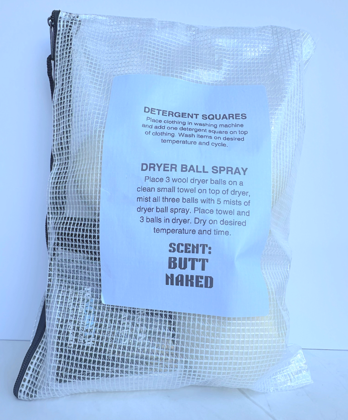 Mesh bag with laundry care instructions and 'Scent: Butt Naked' text on a white background