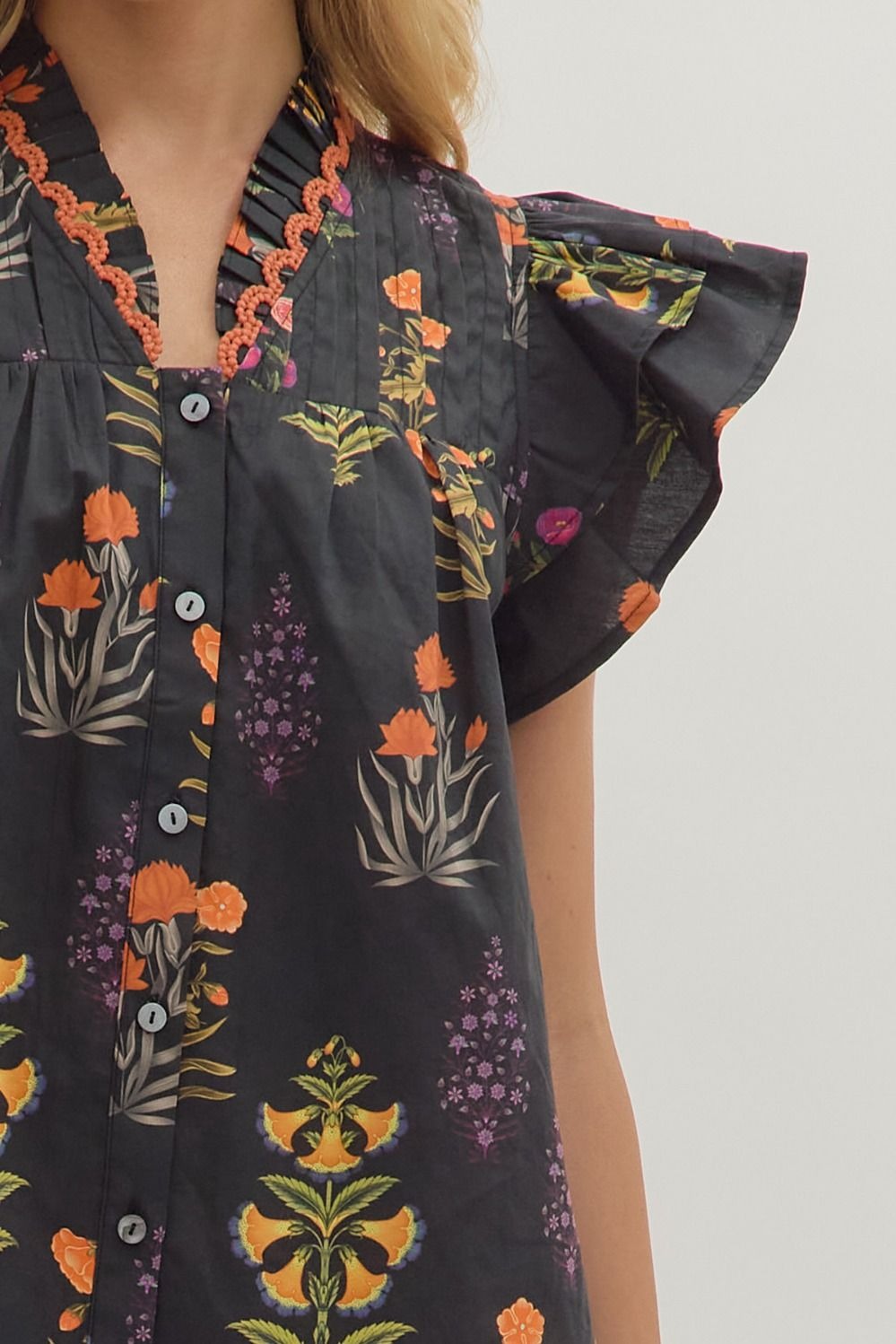 Botanical print short flutter sleeve top featuring pintuck bodice with embroidered trim V-neck