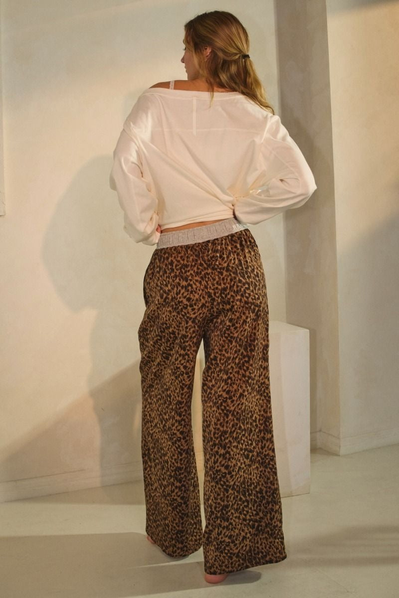 Leopard print wide-leg pants featuring an elastic waistband with button detail and relaxed fit