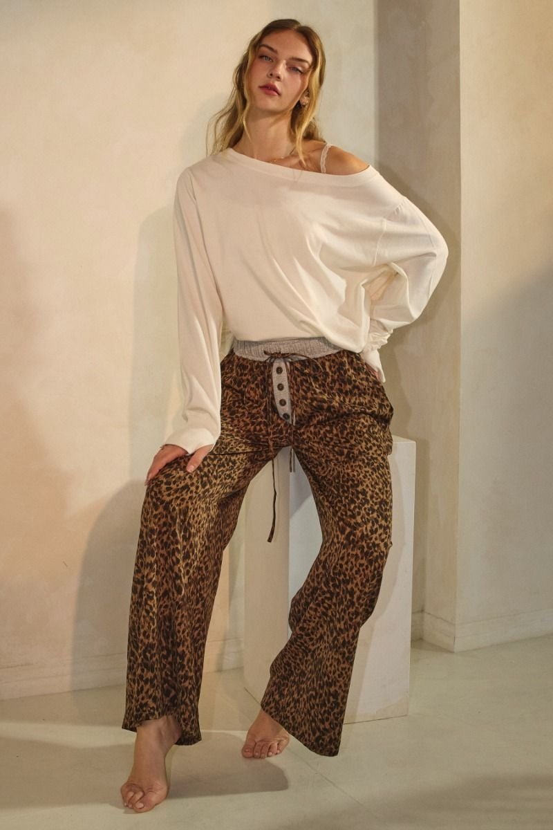 Leopard print wide-leg pants featuring an elastic waistband with button detail and relaxed fit