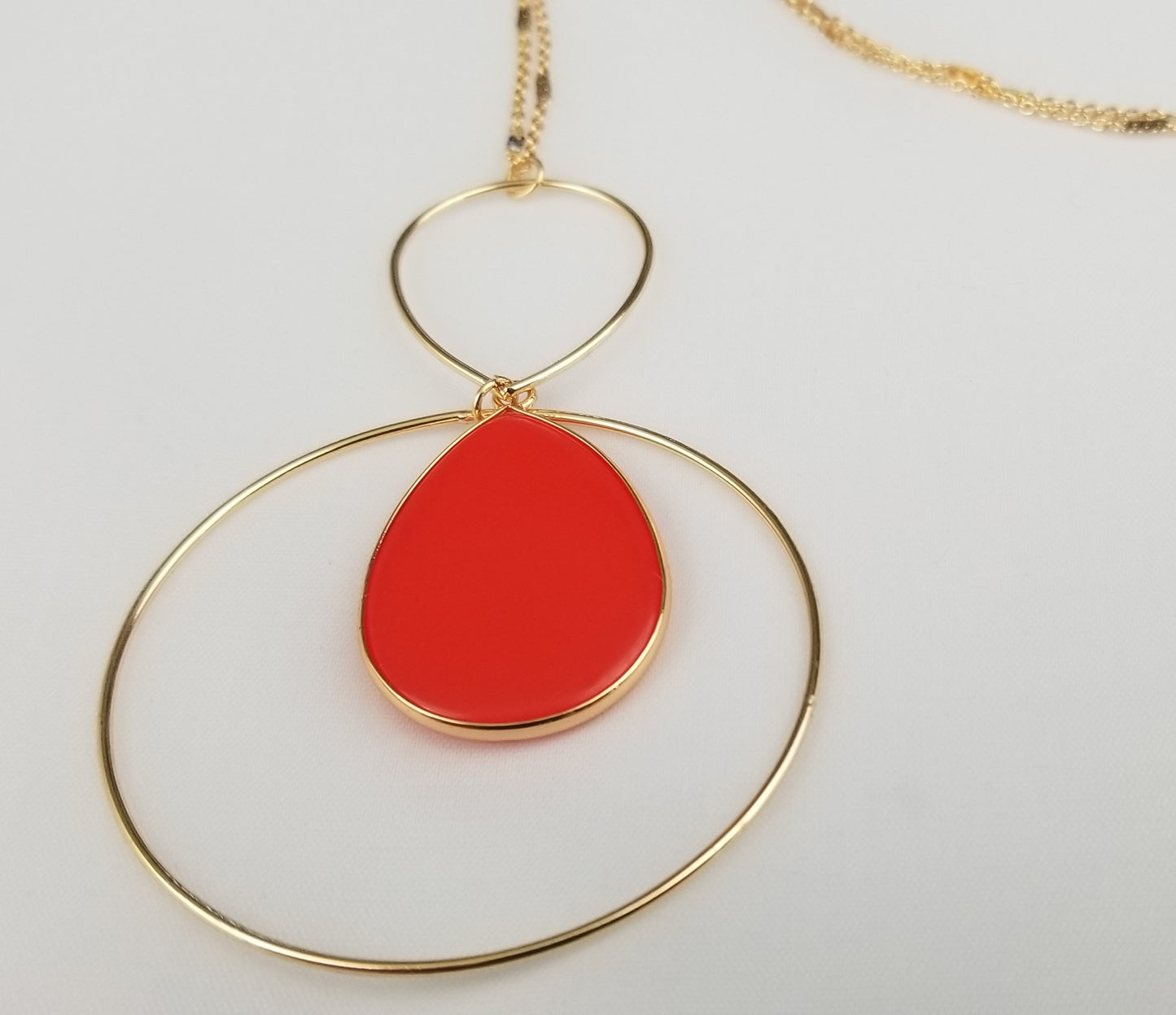 Red teardrop dangle earrings with golden trim Ivy and Pearl Boutique