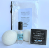 Laundry products including dryer balls, spray bottle, and detergent squares on a light blue background