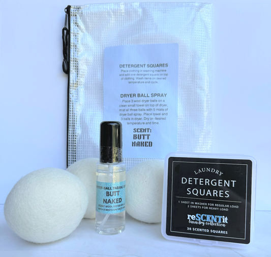 Set of laundry products including dryer balls, spray bottle, and detergent squares on a white background