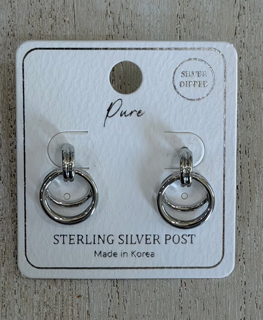 A pair of sterling silver post earrings displayed on a white branded jewelry card, placed on a light wood surface. The card reads 'Pure' and 'STERLING SILVER POST' with 'Silver Diffused' in the top right.