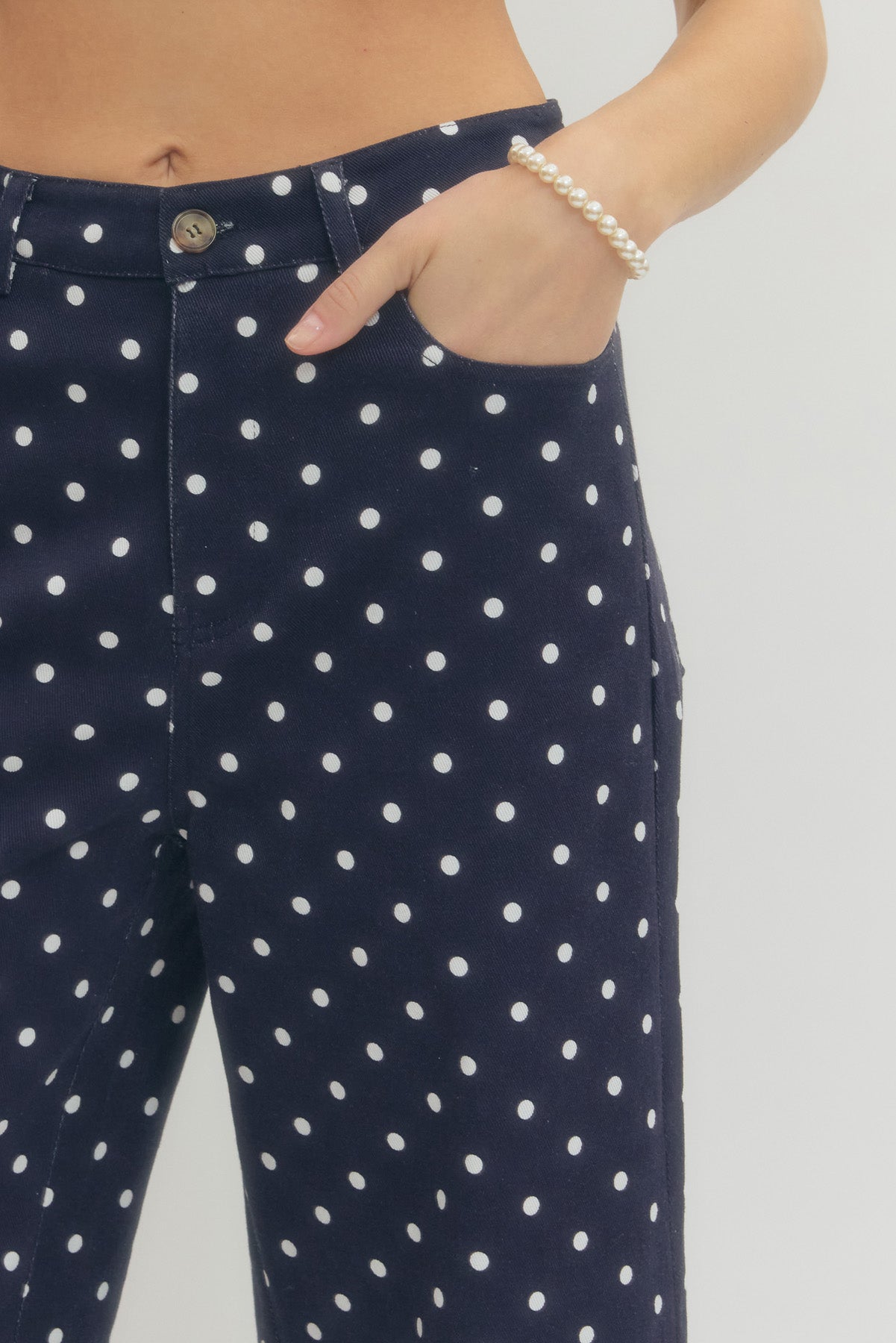 Polka dot wide leg pants featuring button and zip-fly closure at front