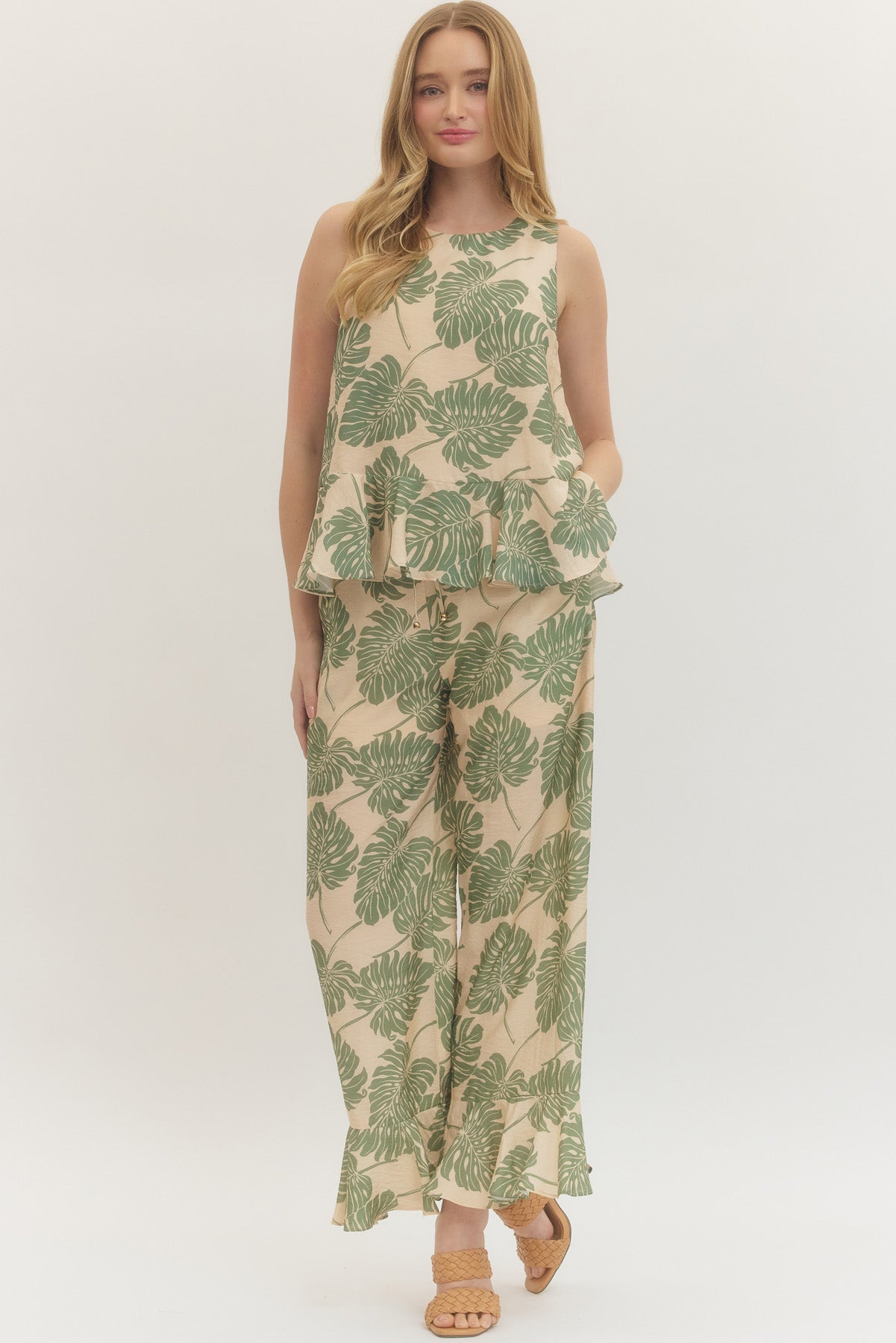 Botanical print sleeveless top featuring ruffle hem detail