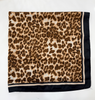 A square scarf with a brown and beige leopard print pattern and a solid black border, laid flat on a white background.