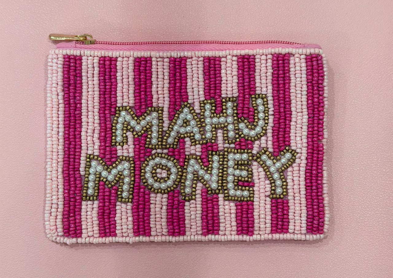 A small rectangular zip pouch covered in pink and white vertical beaded stripes, with the words "MAHJ MONEY" spelled out in raised metallic lettering across the front. The pouch has a gold-tone zipper and is photographed against a soft pink background.