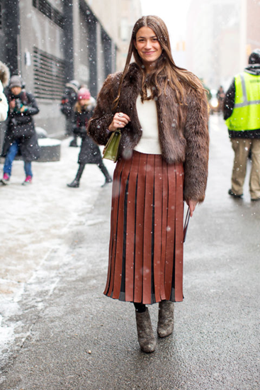 Fur coat adds layers and color to pleated skirt outfit